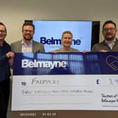 Belmayne's partners hand over the firm's donation to Heather Fawbert, chief executive of Fairplay.
