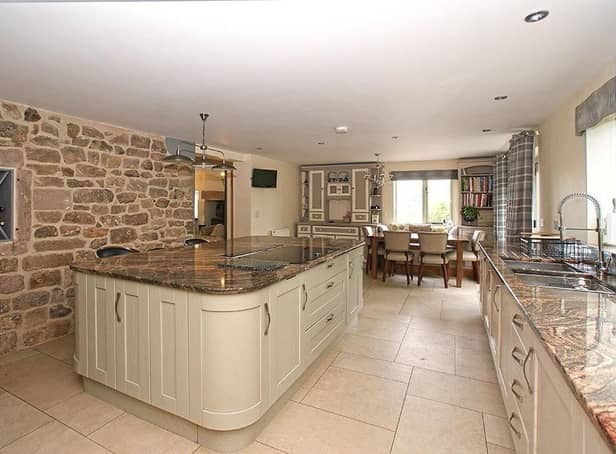 Shaker-style units set beneath a polished granite worksurface with matching upstand, a large island which creates a breakfast bar and an exposed stone wall with an inset wine rack are features of the dining kitchen.  Integral appliances include a 12-place setting dishwasher, two fridges, and eye-level steam oven, microwave oven and conventional oven. The dining area  has a fitted window seat and ample space for a family dining table.  There are views over the open countryside and fields at the rear of the property.