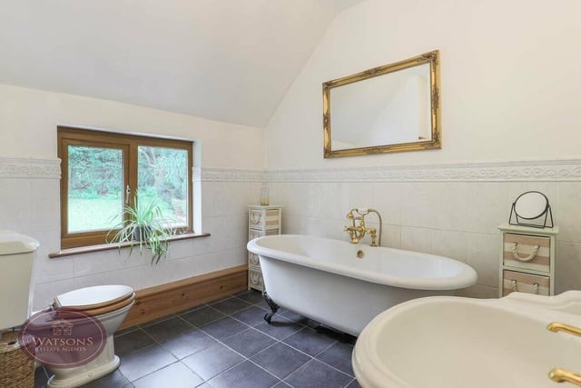 The delightful family bathroom is in keeping with the rest of the historic house, especially the free-standing roll-top bath with mixer shower. There is also a pedestal sink unit, WC, heated towel-rail and tiled flooring.