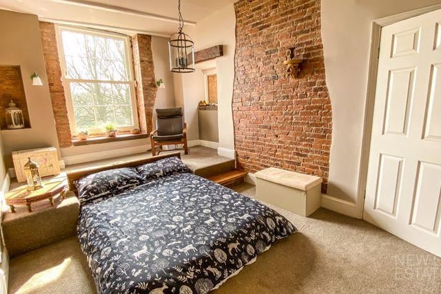 A raised platform at the bedhead and exposed brickwork on the walls are eye-catching features.