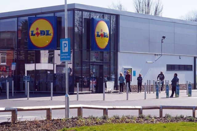 Queuing shoppers observe the two-metre rule outside Lidl