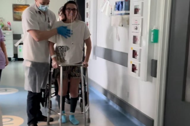 Katya back on her feet with the aid of a walking frame.