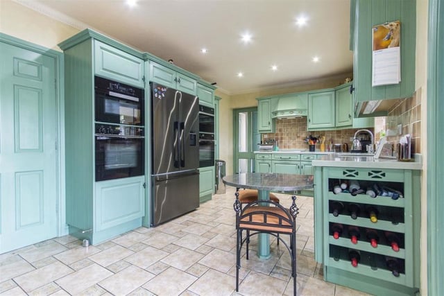 Integral appliances including a dishwasher, microwave oven, steam oven, two electric double ovens and a four-ring hob with extractor over are housed within the kitchen units.