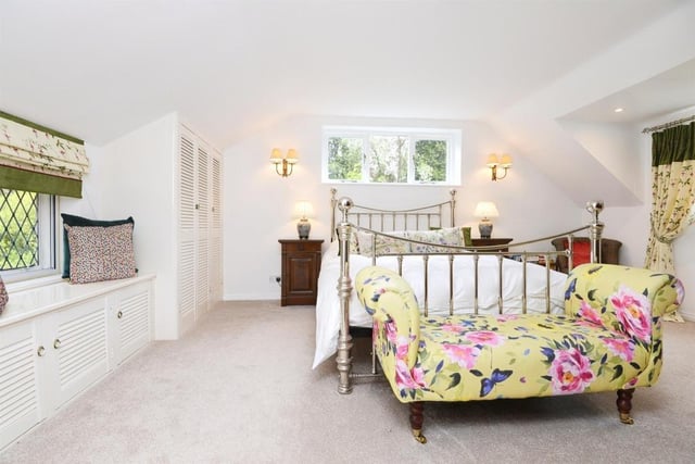 Three sides of this pretty master bedroom have windows, two of which are leaded. The master suite includes two dressing rooms.