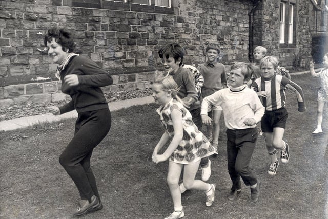 Margaret Andrews leads a game of "follow my leader" at the Eagle Youth club, Newbold, Chesterfield during a play scheme on August 9 1971