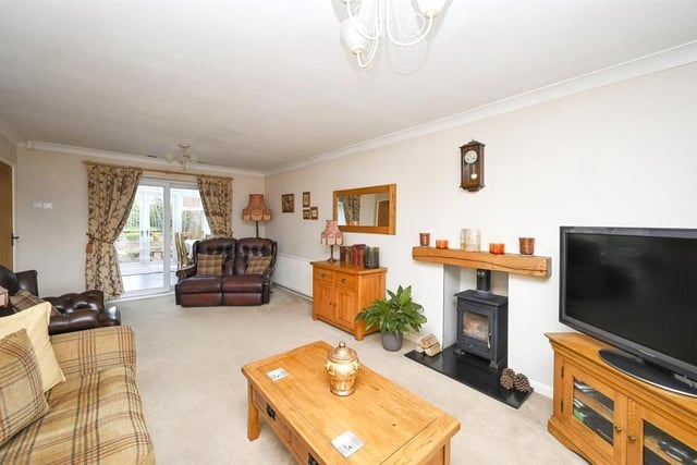 The main reception room is this spacious, dual-aspect lounge, which features a free-standing, multi-fuel burner, inset into the chimney. Double-glazed, sliding doors at the back open into the conservatory.