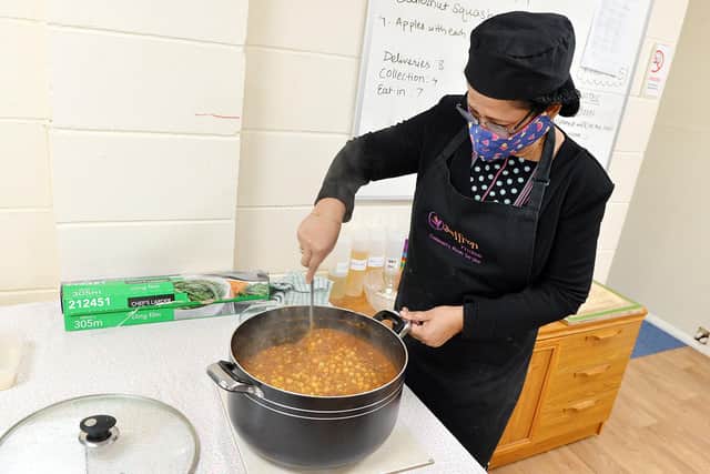 Sushri Wells stirring a chickpea curry.