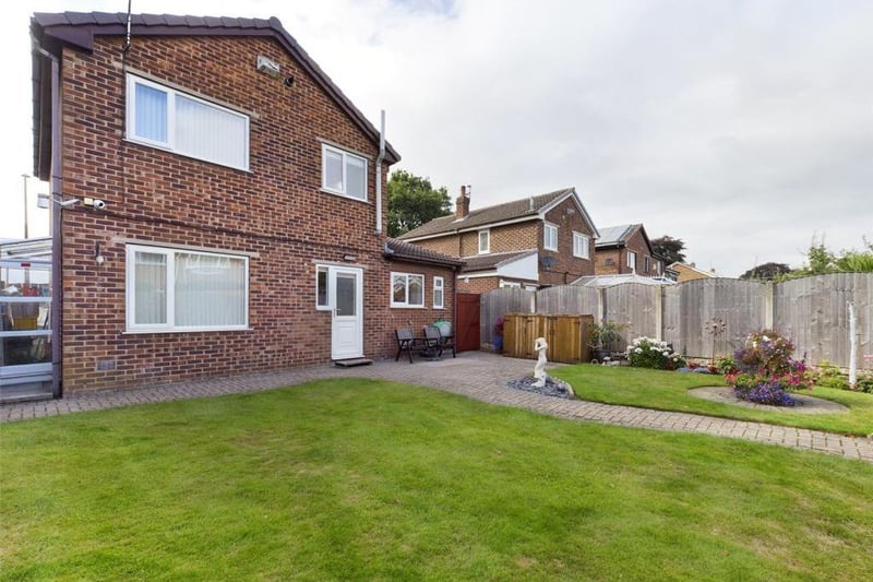 Rear garden - Fence enclosed, laid to lawn with block paved path and raised patio area, flower beds with a variety of plants, flowers and shrubs; timber garden shed, external lighting and garden tap.
