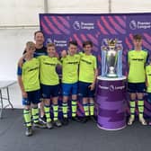 The youngsters are pictured with the Premier League trophy.