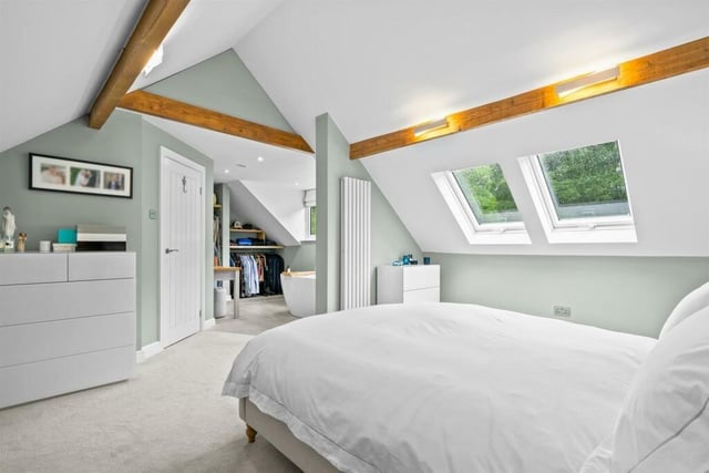 The principal bedroom has twin skylights and original beams with feature lighting,