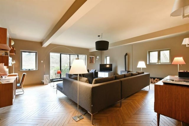 The huge living room boasts a log burner and parquet flooring.