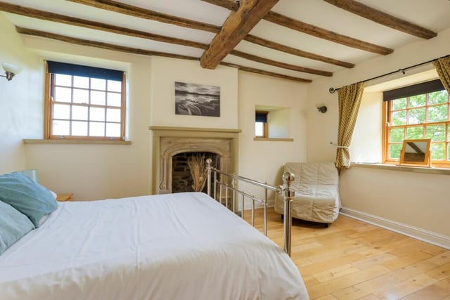 An ornate fireplace, ceiling beams and small panelled windows give this bedroom a really cosy feel.