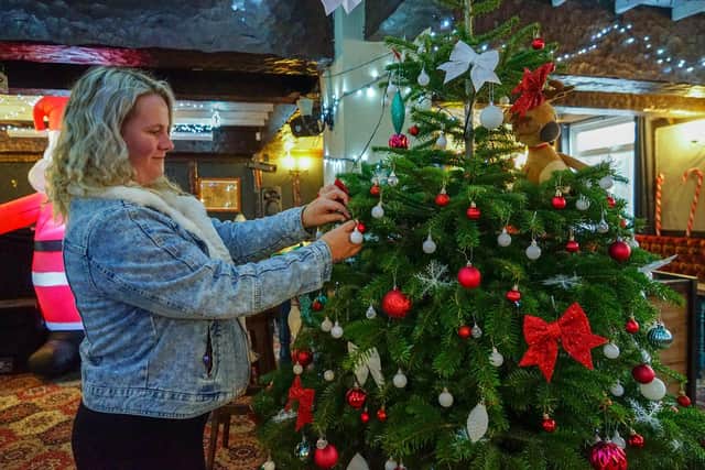 Landlady Sophie Orton decorates a Christmas tree at The Bridge Inn.