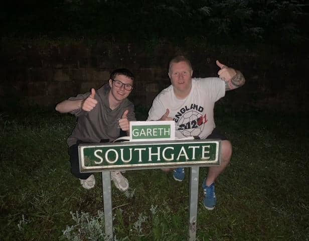 Chris Woolhouse and his stepson Jake Tindale with the amended 'Gareth Southgate' road sign in Eckington
