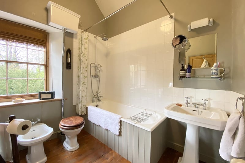 The bathroom has a four-piece Victorian style suite including bath with shower over it, wash hand basin, WC and bidet. It also features wooden flooring.