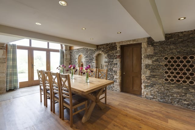 The dining hall with feature stone wall and doors leading outside.