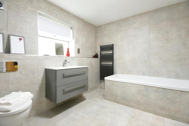 The recently installed family bathroom is fully tiled with WC, hand wash basin and bath.