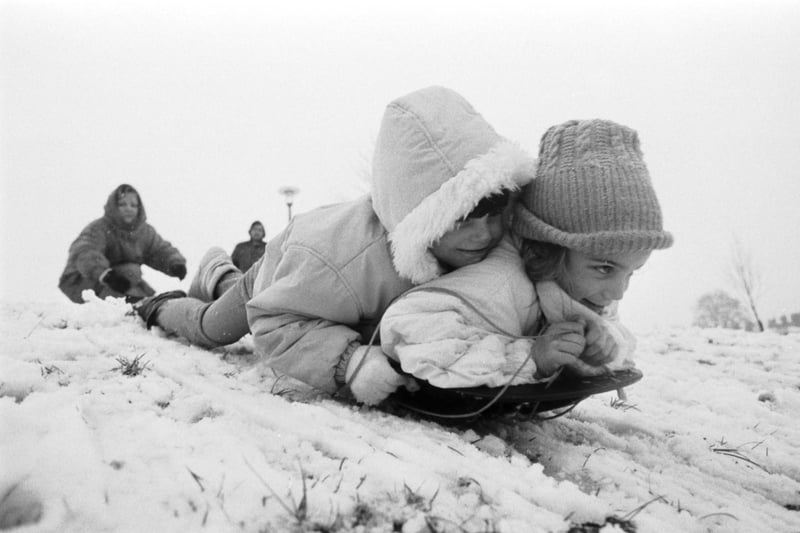 Two little girls sledging at Bruntsfield Links after Edinburgh gets snow showers in February 1989.