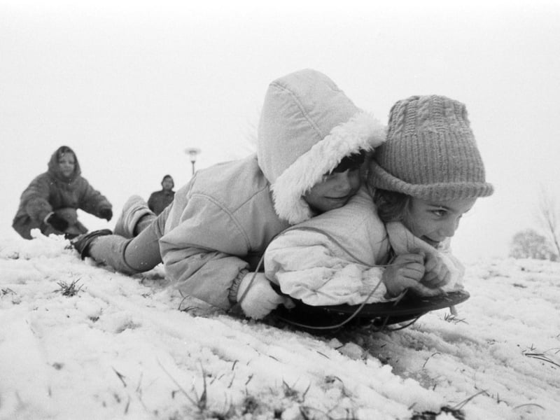 Two little girls sledging at Bruntsfield Links after Edinburgh gets snow showers in February 1989.