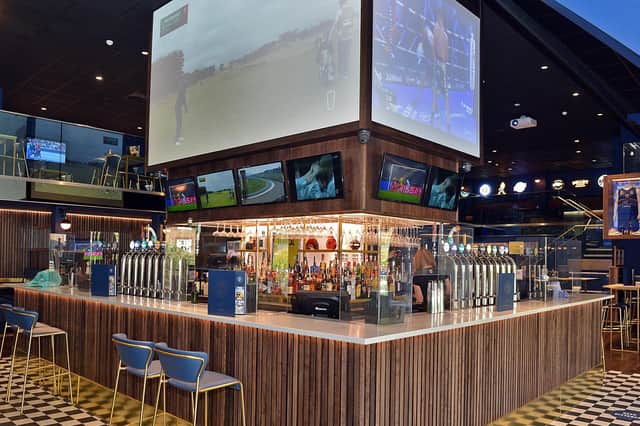The four-sided jumbotron sits above the bar.