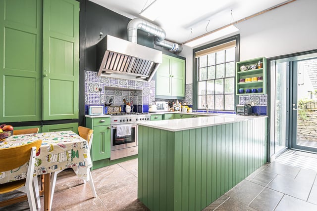 The kitchen decor includes pretty tiles, while the chunky extractor fan has an industrial feel.