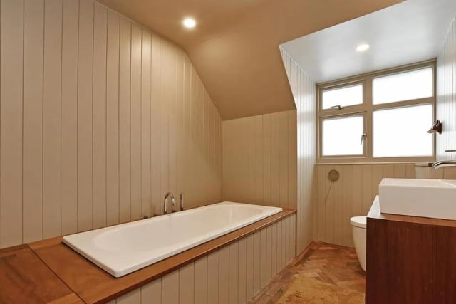 The family  bathroom suite in white is encased in wooden surrounds.