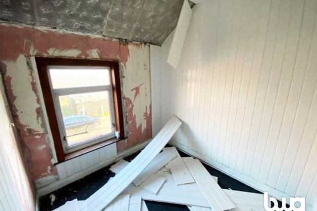 Now some of the property's issues are becoming evident. The smallest of the three bedrooms has had part of its wood panel wall stripped back and the result is not pretty.
