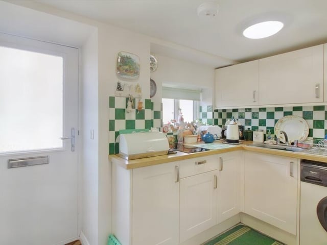 The kitchen is fitted with storage cupboards and has a two-ring induction hob, electric oven and plumbing for a washing machine.