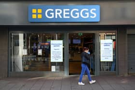 A woman wearing a face mask walks past a Greggs bakery. Picture: GEOFF CADDICK/AFP via Getty Images.