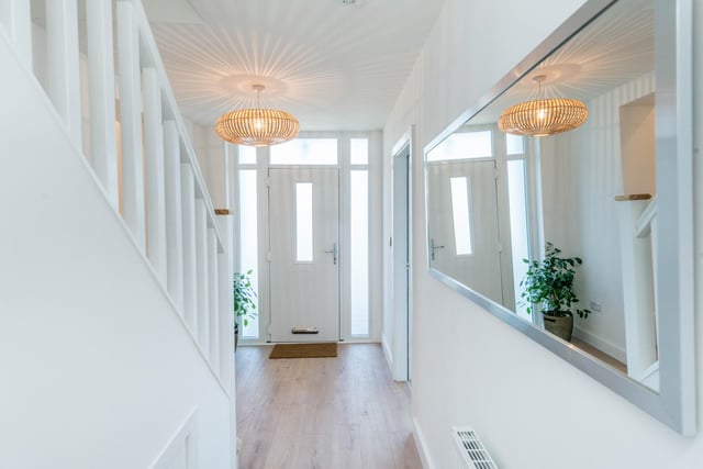 The hallway features crisp white walls and stripped-back flooring.