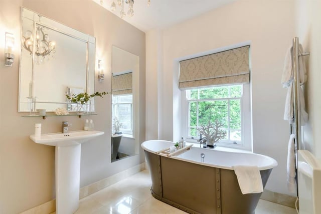 The luxurious bathroom has a  grand free-standing bath and oversized walk-in shower.