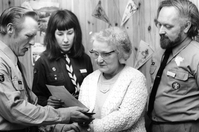 George Simpson, deputy group Scout leader, presents a replica of the group's neckerchief to Mrs Mary Cleveland in recognition of her 25 years' service to the South Shields 22nd Scout Group in 1971.