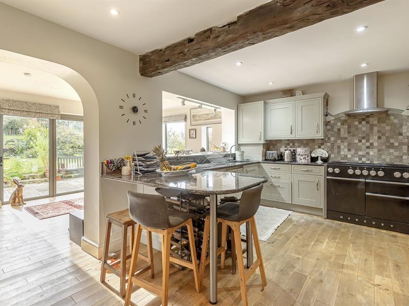 The open plan kitchen is fitted with modern units, integrated appliances and a breakfast bar, all fitted with solid oak flooring.