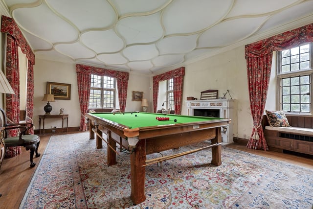 A billiard room  has an oak window seat.