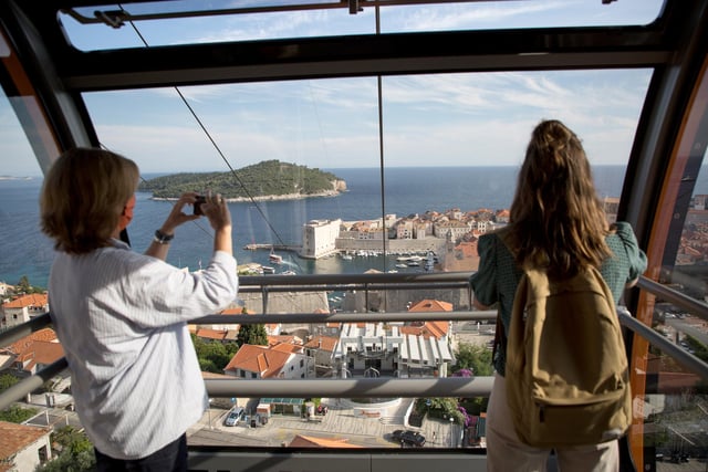 Tourists in a cable car are seen taking photos of the old town of Dubrovnik - flights to Dubrovnik and Pula can be booked from Doncaster Sheffield Airport.