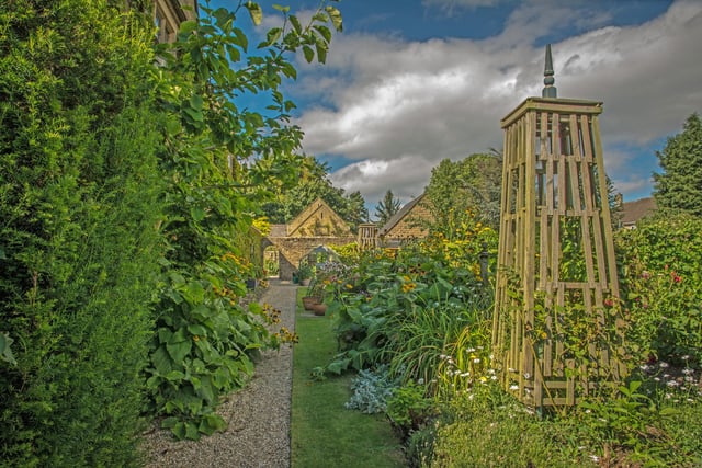 Alongside the wing of the Garden House, the owners have created a walled vegetable garden with walkways between.
