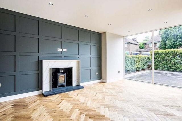 Parquet flooring and a marbled fireplace elevate the living room.