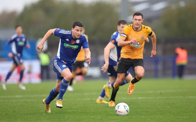 Connor Dimaio runs with the ball during the Emirates FA Cup First Round match between Curzon Ashton and Cambridge United  at Tameside Stadium. (Photo by Nathan Stirk/Getty Images)