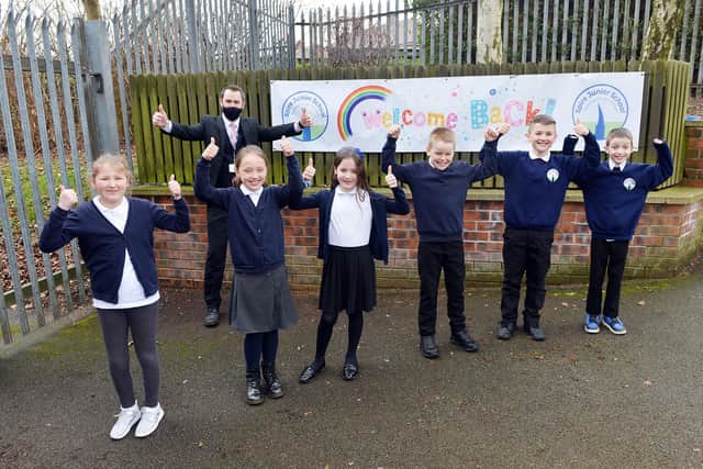 Happy children at the welcome sign at Spire Junior School