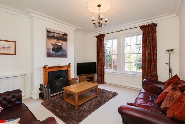 The sitting room, with its feature fireplace, is accessible via a central staircase with spacious landings.