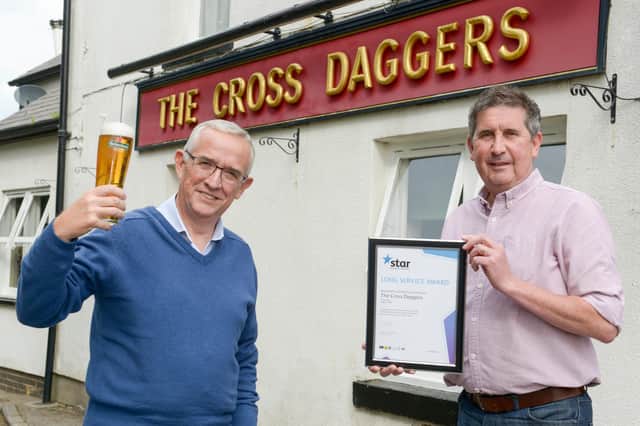 Anthony Hutchinson receives a long service award from Star Pubs and Bars area manager Neil Bircumshaw after 20 years at the pub.
