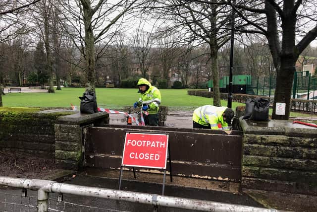 Temporary flood barriers being deployed in Hall Lees Park, Matlock.