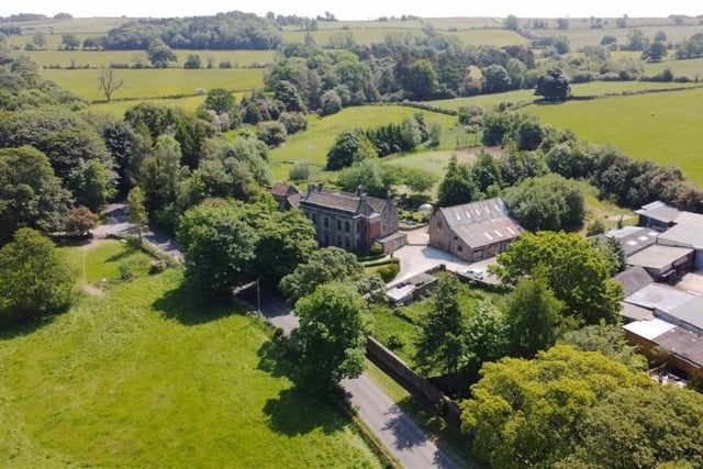 The property includes a former farmhouse adjacent to the main house, a cottage, outbuildings and a paddock across the road.
