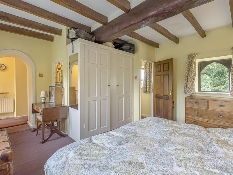 The property features four bedrooms in total, with the master benefiting from a beamed ceiling and an en-suite shower room.