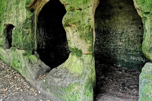 The simple cave has openings for a door and windows, and a cross engraved on one wall. On the outside is a large collection of carved inscriptions that has accumulated over the centuries.