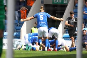 Ash Palmer is mobbed by his team-mates after scoring against Oldham Athletic. Picture: Tina Jenner.