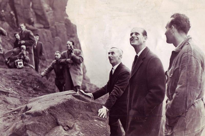 The Duke of Edinburgh looks up... and smiles. What's up there?  Boys rock climbing at Castle Naze during one of the Duke's visits to Derbyshire.