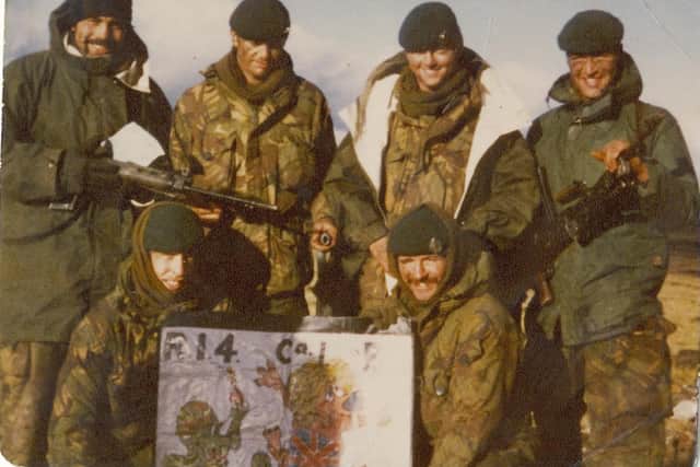 Gary (third from the left standing up) and other soldiers in the Falklands Islands posing after the victory.