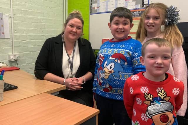 Children from Barrow Hill Academy wearing their Christmas jumpers at the school fayre. They’re pictured with headteacher Rebecca Vodden-Page. 