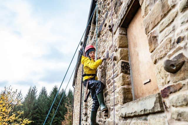 Young person Abseiling up a wall as part of an activity at Camps for All